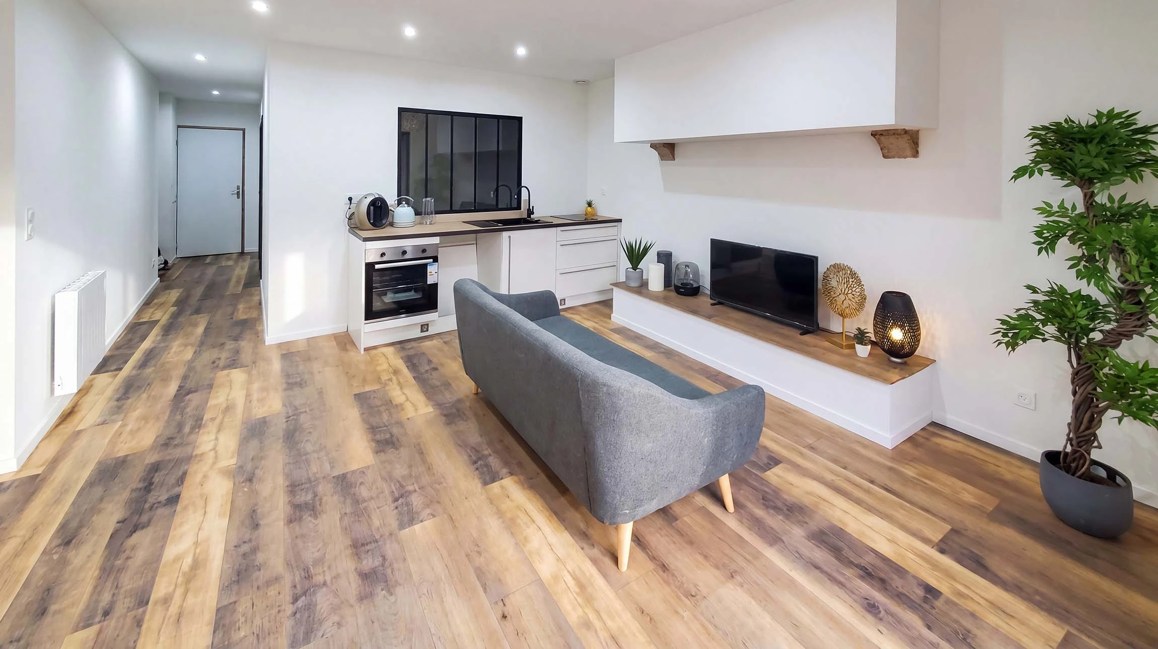 Plasterer utilisant une torche de finition pour lisser un nouveau plâtre à la surface d'un mur à l'intérieur d'une maison pendant les travaux de rénovation ou de construction